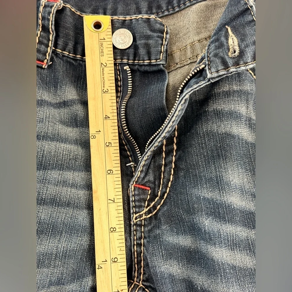 True Religion jeans feature a dark wash and bold signature stitching. Skinny